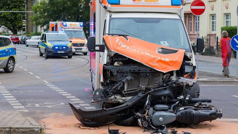 Kaputter Rettungswagen, davor ein zerstörtes Krad