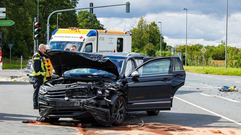 Ein Auto mit Frontalschaden steht auf einer Straße, Trümmerteile liegen daneben