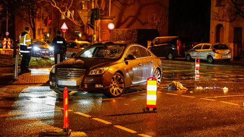 Mercedes auf einer Kreuzung im Regen in Dunkelheit, daneben ein Polizeiwagen