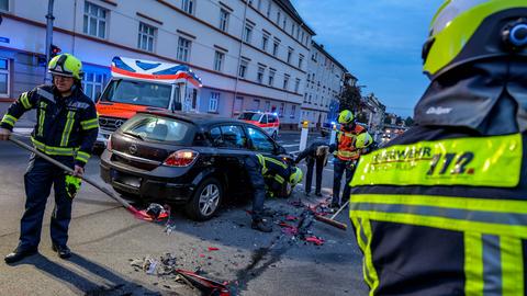 Einsatzkräfte reinigen die Straße, Ermittler am verunfallten Auto