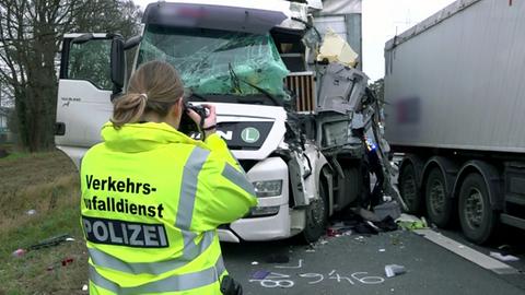 Ermittlerin fotografiert Unfallstelle mit kaputtem Lastwagen