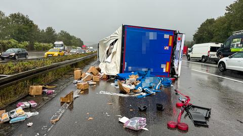 Umgekippter Lkw, davor Pakete mit Bettwäsche