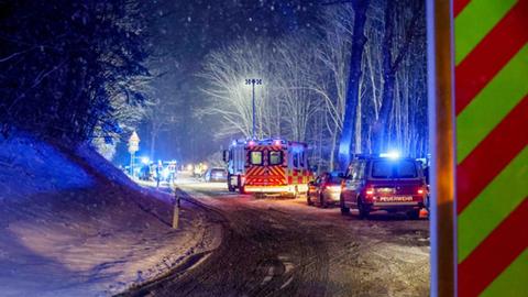 Einsatzfahrzeuge an der verschneiten Unfallstelle.