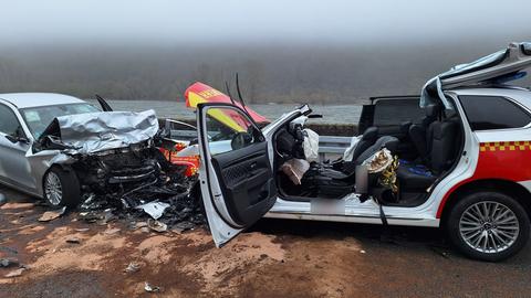 Zwei Autos stehen sich frontal gegenüber, beide Motorhauben sind kaputt.