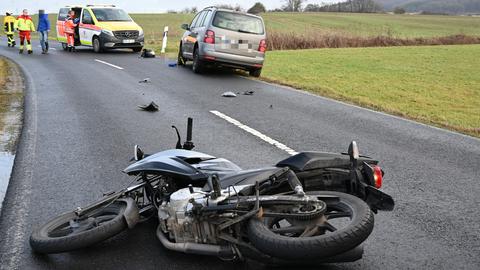 Ein Motorrad liegt quer auf der Straße, es fehlen Teile. Dahinter steht ein Krankenwagen.