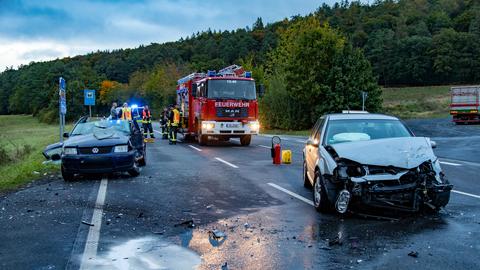 Zwei zerstörte Autos und ein Feuerwehrauto auf einer Landstraße