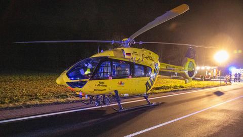 Ein gelber Rettungshubschrauber steht auf einer Landstraße