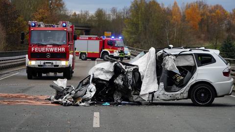 Verunfalltes Auto steht auf Landstaße, ringsherum Einsatzkräfte