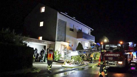 Feuerwehrauto vor Haus, Schläuche auf der Straße