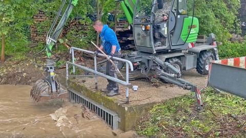 Baggerarbeiten auf schlammigem Weg an Bach