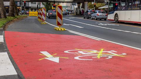 Rote Fahrradspur und Warnbaken um einen abgesperrten Bereich auf einer Straße in Gießen