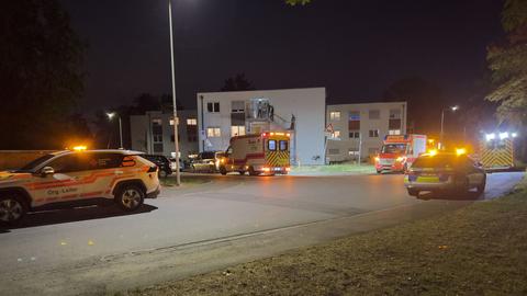 Polizei und Feuerwehr vor einem Gebäude mit Licht und Menschen