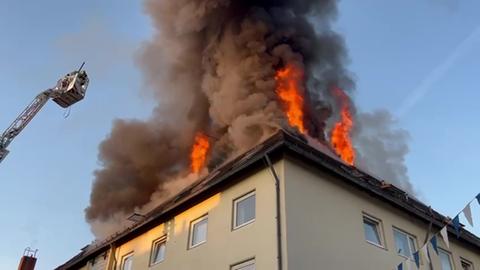 Flammen drängen aus Hausdach