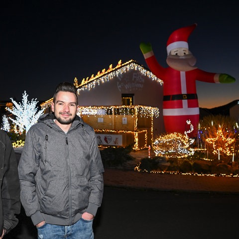 Zur blauen Stunde wird das Weihnachtshaus das erste Mal in dieser Saison in voller Beleuchtung gezeigt. Dominik Pieczko (l) und Sascha Bärwald haben für die prachtvolle Weihnachts-Illumination rund 65 000 LEDs verwendet.