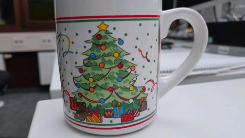 Kaffeetasse mit Tannenbaum und Geschenken