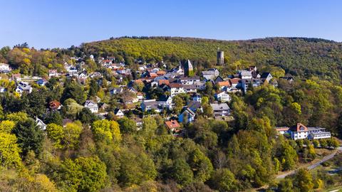 Foto eines kleinen Ortes (aus der Ferne), der inmitten von Wald und Landschaft liegt.