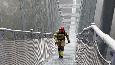 Ein Feuerwehrmann läuft in voller Montur über den Skywalk.