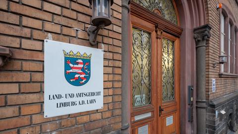 Außenansicht einer Fassade am Eingang mit einem Hinweisschild, auf dem steht: "and- und Amtsgericht Limburg an der Lahn".