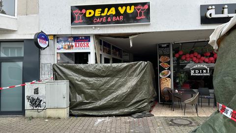 Zerstörter Eingangsbereich des Cafés, ein Teil ist mit einer Plane abgehängt