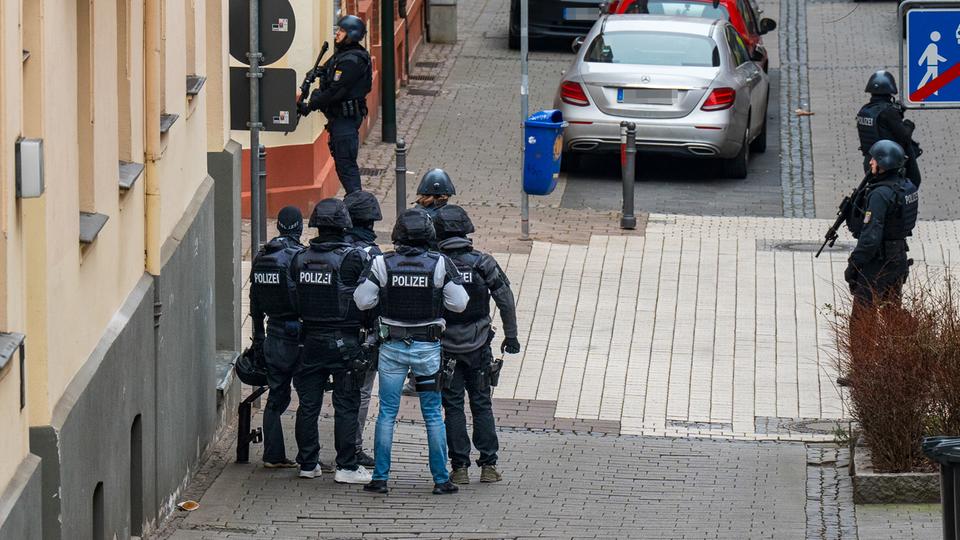 Vermummte und bewaffnete Polizisten an einer Straßenecke