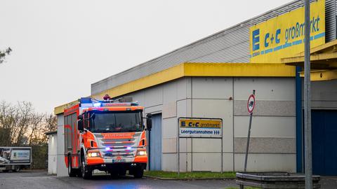 Ein Feuerwehrauto vor einem Edeka-Großmarkt in Wiesbaden, einem großen, grauen, fensterlosen Gebäude