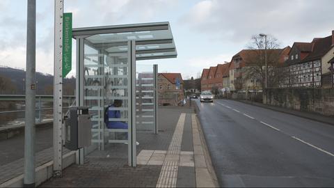 Ene Bushaltestelle ist lniks zu sehen, ein Auto fährt auf dfer Fahrbahn. 