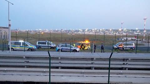 Einsatzkräfte der Bundespolizei untersuchen ein Loch, das die Aktivisten am Frankfurter Flughafen in den Zaun geschnitten haben.