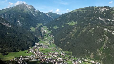 Blick auf das Zillertal, aufgenommen vom Steinerkogel aus: Unten im Tal Häuser, umsäumt vom Gebirge