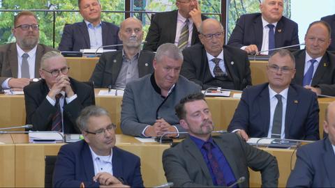 Der AfD-Abgeordnete Marxen sitzt mit weißer Creme im Gesicht im Landtag.