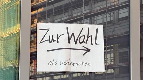 Zettel an einer Scheibe. Darauf steht: Zum Wahllokal als weitergehen