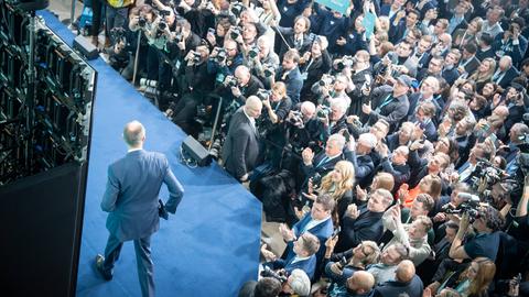 CDU-Kanzlerkandidat tritt vor Anhängern der CDU auf eine Bühne in der CDU-Parteizentrale. Er ist von oben fotografiert.