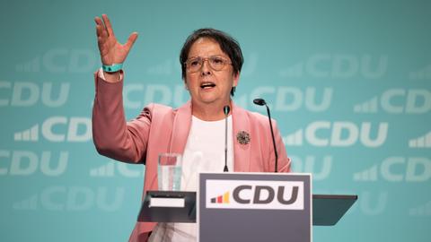 Eine Frau steht an einem Redepult und spricht gestikulierend. Vor auf dem Pult ein Schild mit der Aufschrift "CDU".