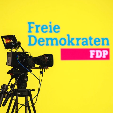 Eine Kamera zeigt auf ein FDP-Logo