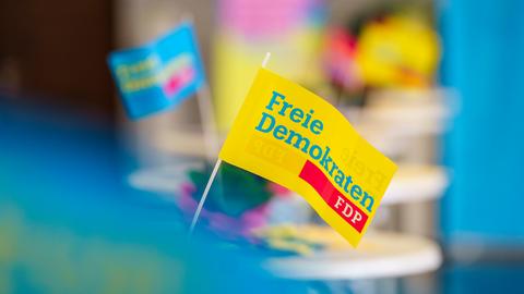 FDP-Fähnchen stehen an einem Wahlkampfstand.