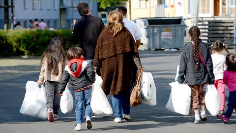 Eine Familie wird auf dem Gelände der Erstaufnahmeeinrichtung für Flüchtlinge in Gießen zu ihrer Unterkunft geleitet