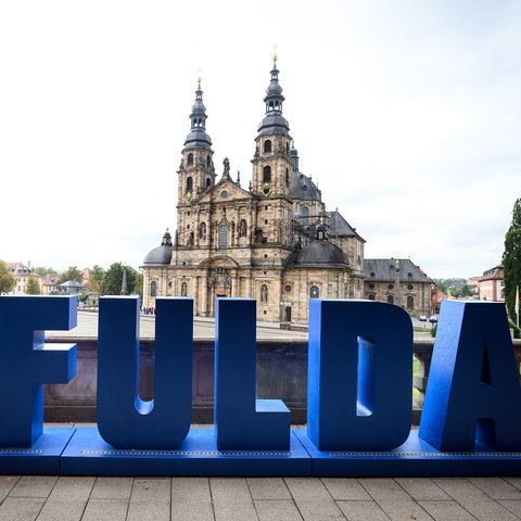 Ein Schriftzug Fulda in blau mit einem roten Herz vor dem Dom von Fulda