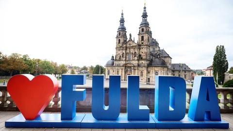 Ein Schriftzug Fulda in blau mit einem roten Herz vor dem Dom von Fulda