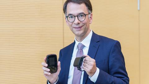 Hessens Justizminister Christian Heinz (CDU) mit dem spanischen Modell der elektronischen Fußfessel.