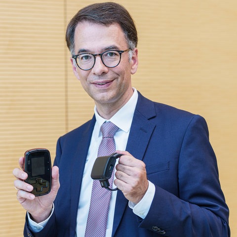 Hessens Justizminister Christian Heinz (CDU) mit dem spanischen Modell der elektronischen Fußfessel.