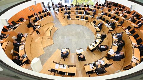 Die Abgeordneten im Landtag sitzen bei einer Sondersitzung in einem Raum hinter ihren Tischen.