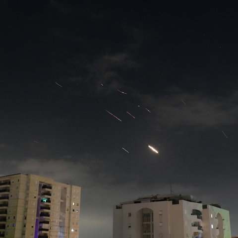 Flammen von Explosionen in der Nacht am Himmel über Tel Aviv, während Israels Raketenabwehrsystem Raketen und Drohnen aus dem Iran abfängt. 