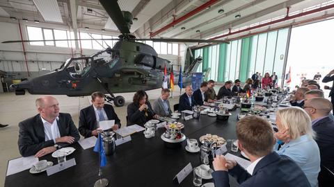 Das hessische Kabinett in einem Hangar auf dem US-Airfield vor einem "Tiger"-Kampfhubschrauber der Bundeswehr.
