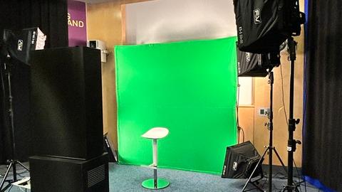 Die Wand im Studio ist leuchtend grün (Greenscreen), davor steht eine schwarze Box, in der sich eine Kamera befindet. Die Kandidaten können auf einem Stuhl vor der Kamera Platz nehmen und Fragen beantworten.