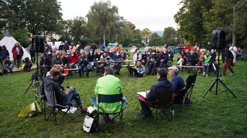 OB Schoeller sitzt in einer Gruppe vor Publikum