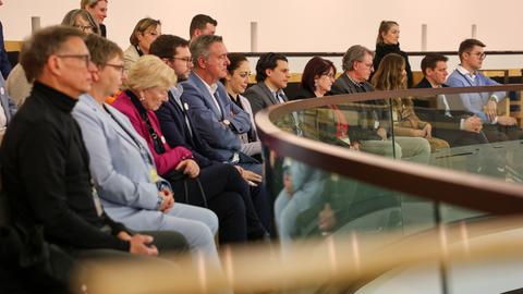 Auf der Besuchertribüne des Hessischen Landtags sitzen mehrere Politikerinnen und Politiker.