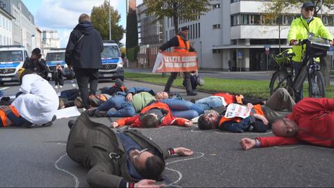 Menschen liegen auf der Straße, um sie herum sind Linien gezogen