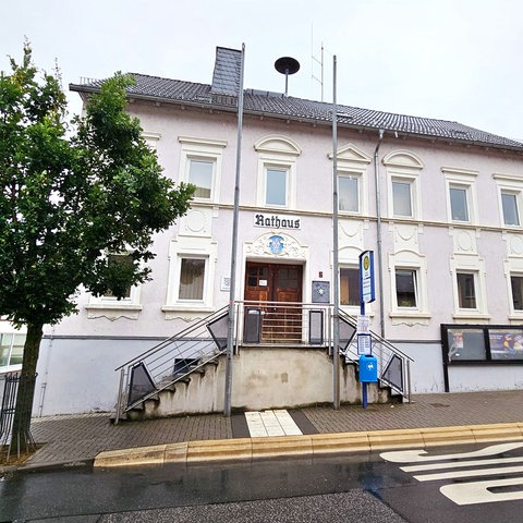 Zweigeschossiges historisches Gebäude von außen. Über der Eingangstür steht "Rathaus" 