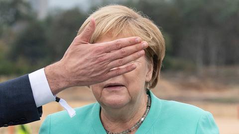 Angela Merkel mit Hand vor dem Gesicht