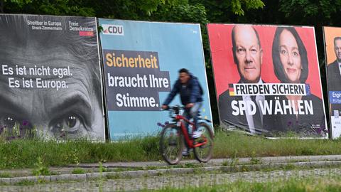 Ein Radfahrer fährt im Frankfurter Stadtteil Sachsenhausen an Großplakaten von FDP (l-r), CDU, SPD und Freien Wählern zur Europawahl vorbei 