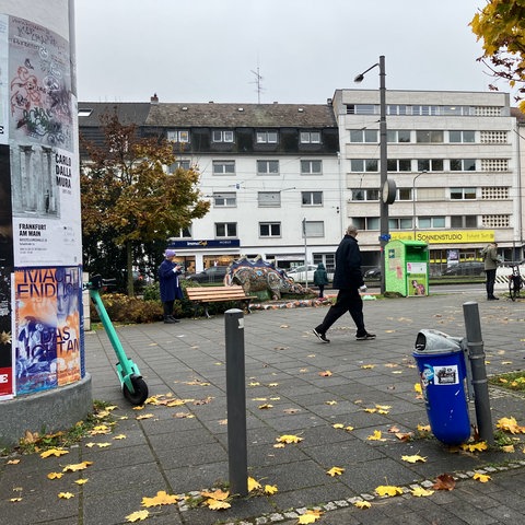 Ein Platz mit Mülltonne, Litfaßsäule und Pflaster vor einem Zugang zur U-Bahn